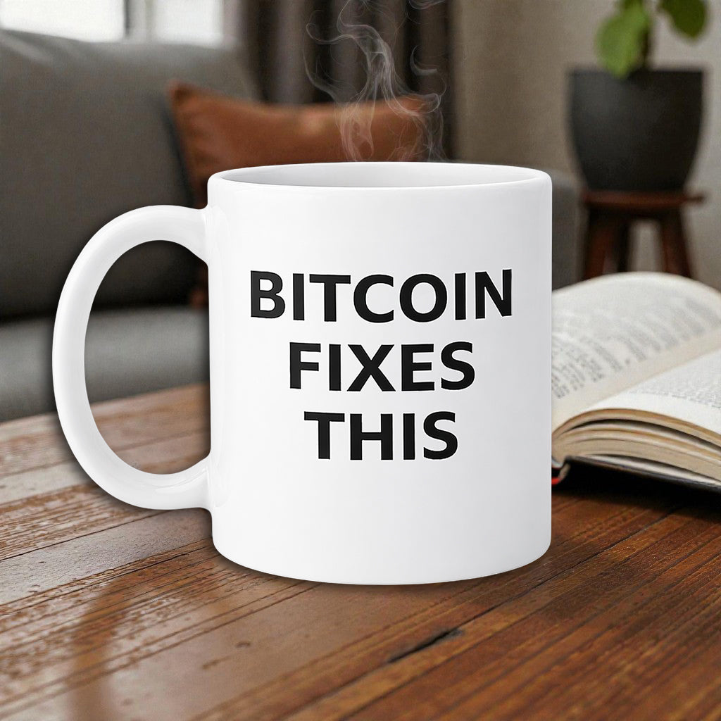 Holztisch weiße Bitcoin Tasse mit „Bitcoin Fixes This“