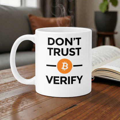 weiße Bitcoin Tasse mit „Don’t Trust. Verify.“ auf holz schreibtisch