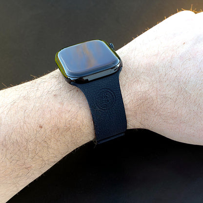Apple Watch Armband in Schwarz am Handgelenk getragen mit sichtbarem Bitcoin BTC Logo auf der Vorderseite