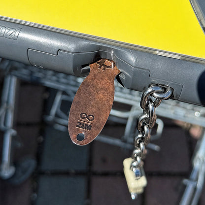 Bitcoin Einkaufswagenlöser in Dark Bronze im Münzschlitz eines Einkaufswagens eingesteckt als praktische Alternative zur Münze