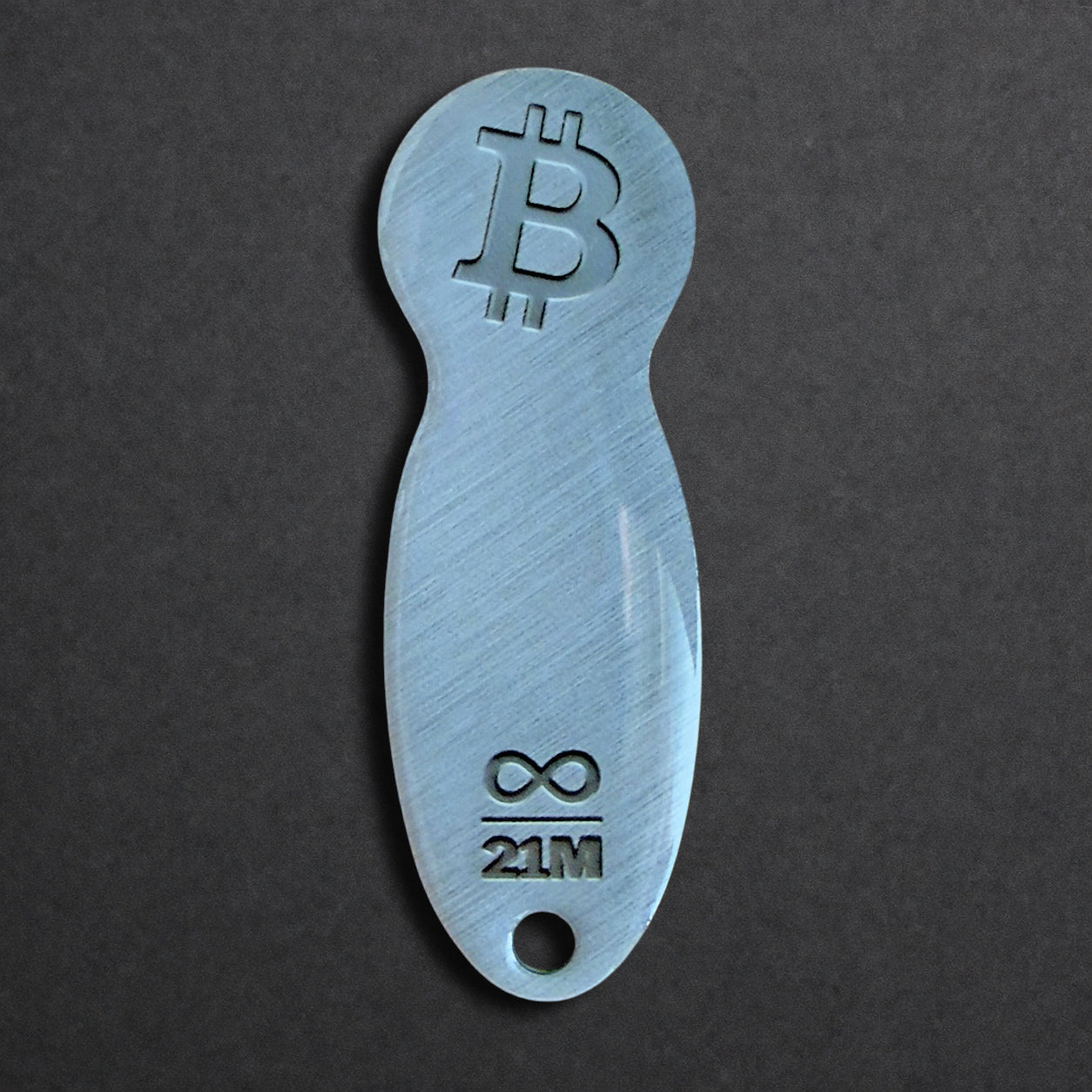 Bitcoin Einkaufswagenlöser aus Edelstahl in Edelstahl Optik, frontal von oben fotografiert, kompakt und schlüsselbundtauglich