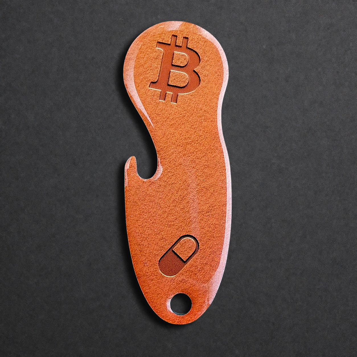 Bitcoin Einkaufswagenlöser aus Edelstahl in Orange Pill, frontal von oben fotografiert, mit integriertem Flaschenöffner