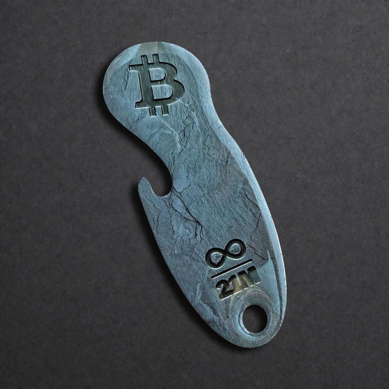 Detailaufnahme eines Bitcoin Einkaufswagenlösers aus Edelstahl in Schiefer Anthrazit mit Flaschenöffner in schräger Perspektive
