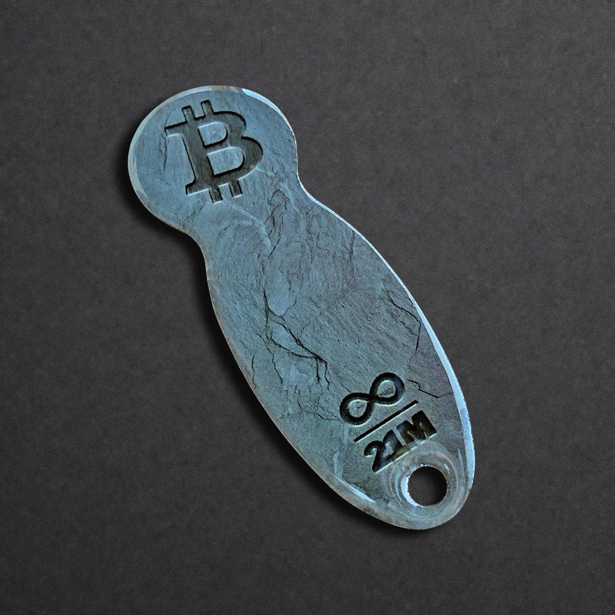 Detailaufnahme eines Bitcoin Einkaufswagenlösers aus Edelstahl in Schiefer Anthrazit in schräger Perspektive