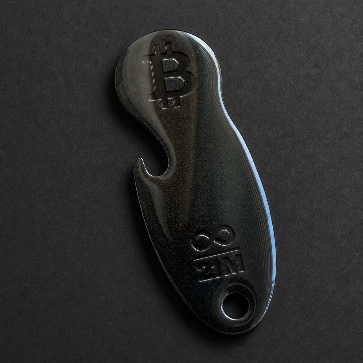 Detailaufnahme eines Bitcoin Einkaufswagenlösers aus Edelstahl in Schwarz Matt mit Flaschenöffner in schräger Perspektive