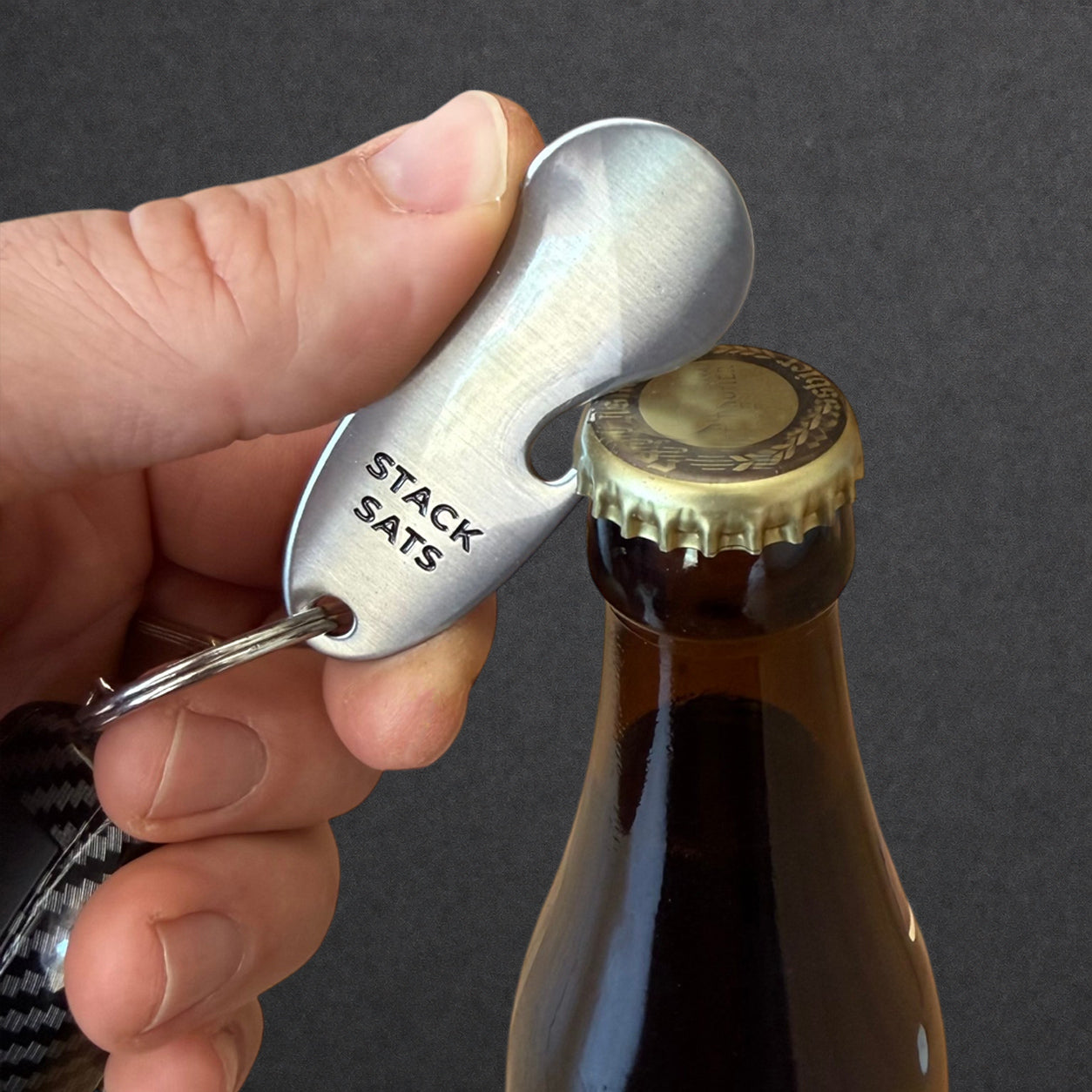 Bitcoin Einkaufswagenlöser in Color Stripes wird als Flaschenöffner zum Öffnen einer Getränkeflasche verwendet